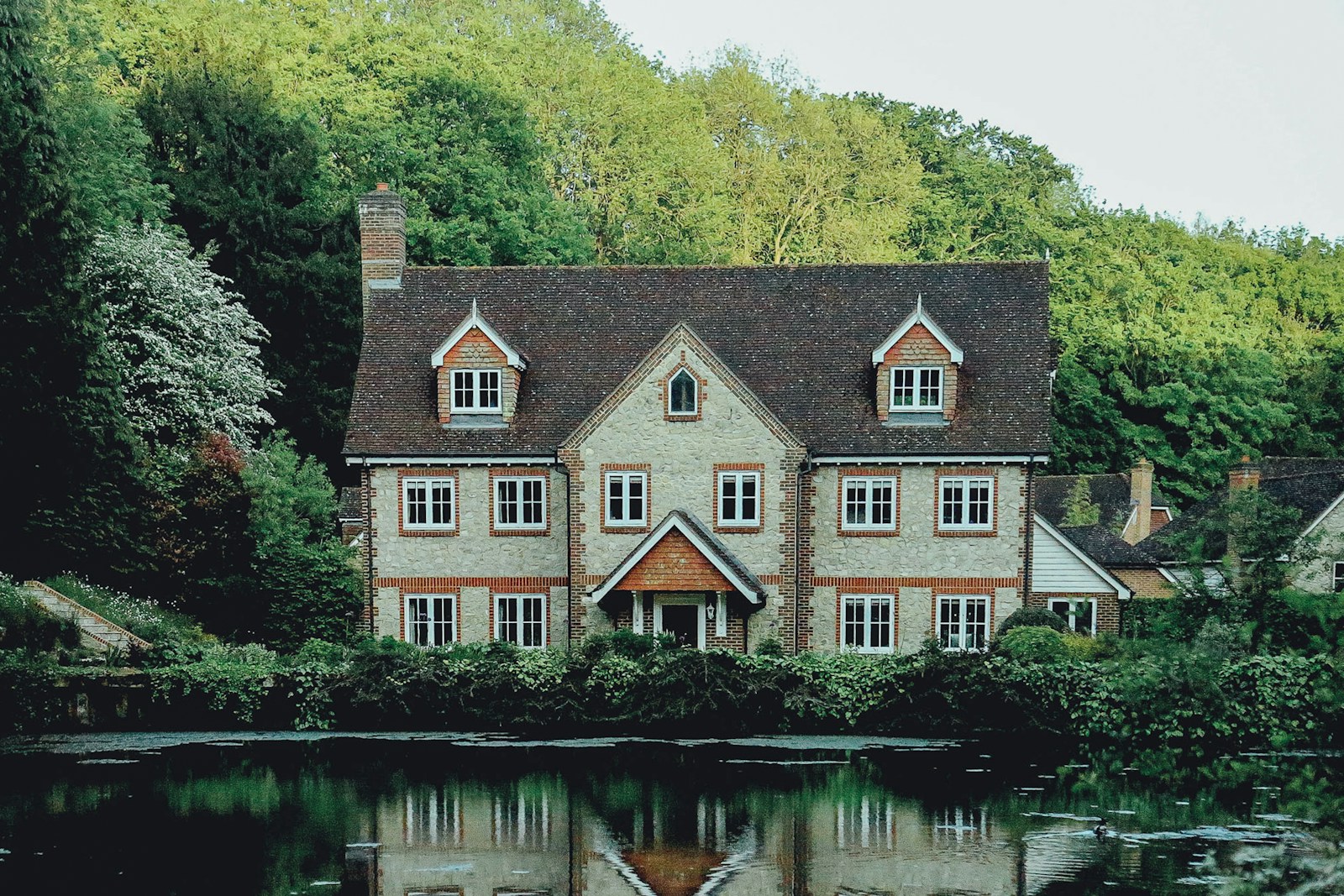 insurance premium concrete house near a body of water and forest